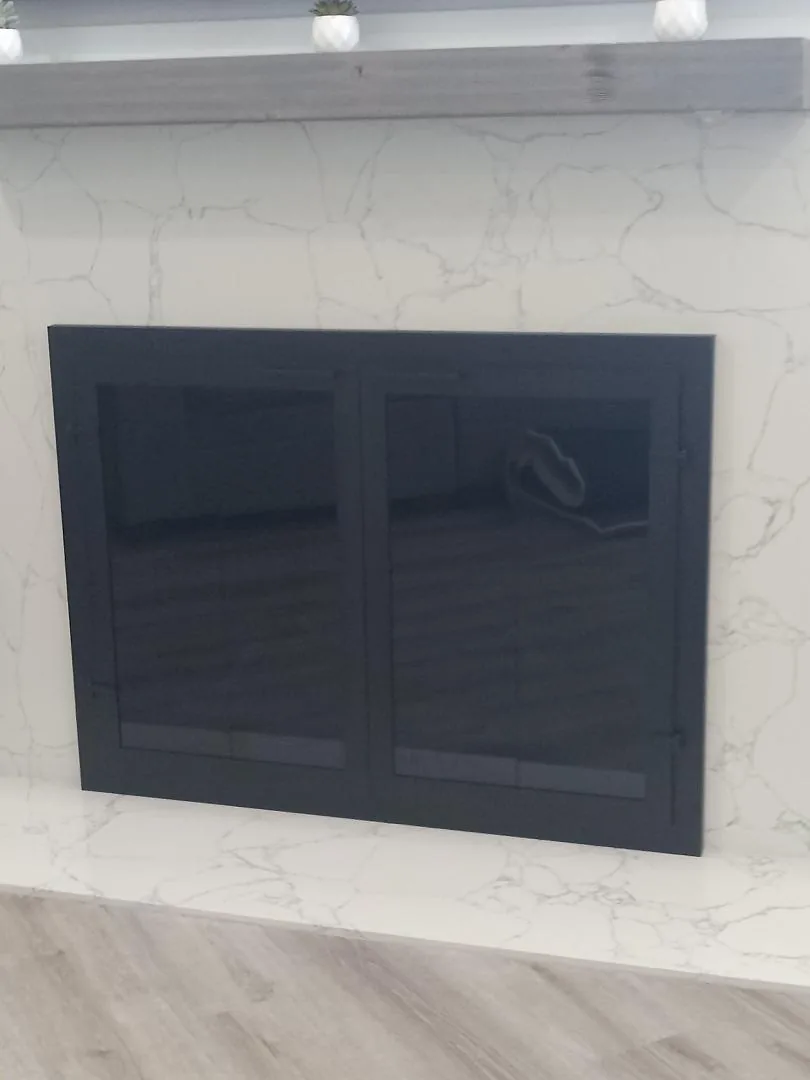 Black fireplace doors fitted to an existing fireplace opening Black fireplace doors fitted to an existing fireplace opening
